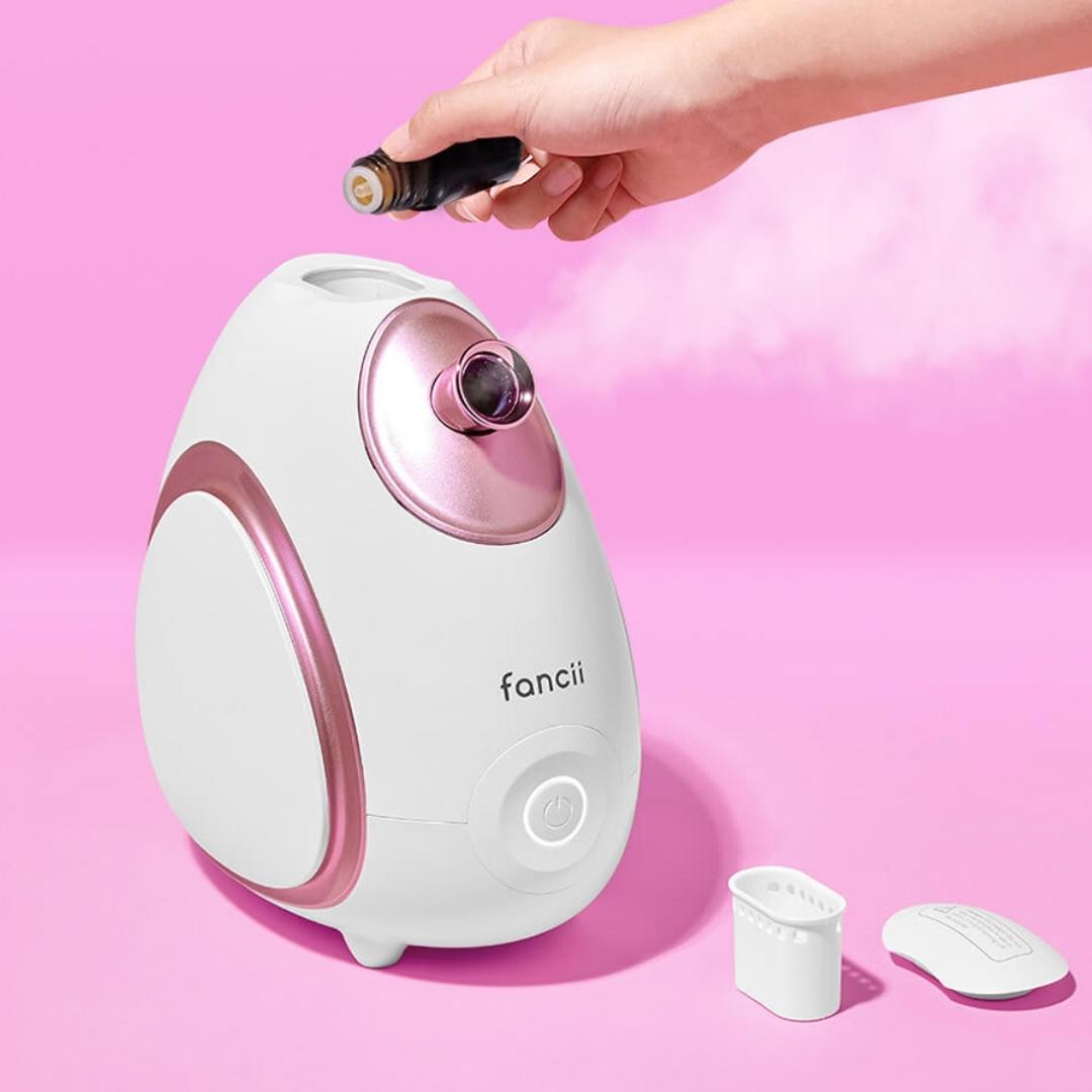 Woman using rivo facial steamer with essential oil compartment