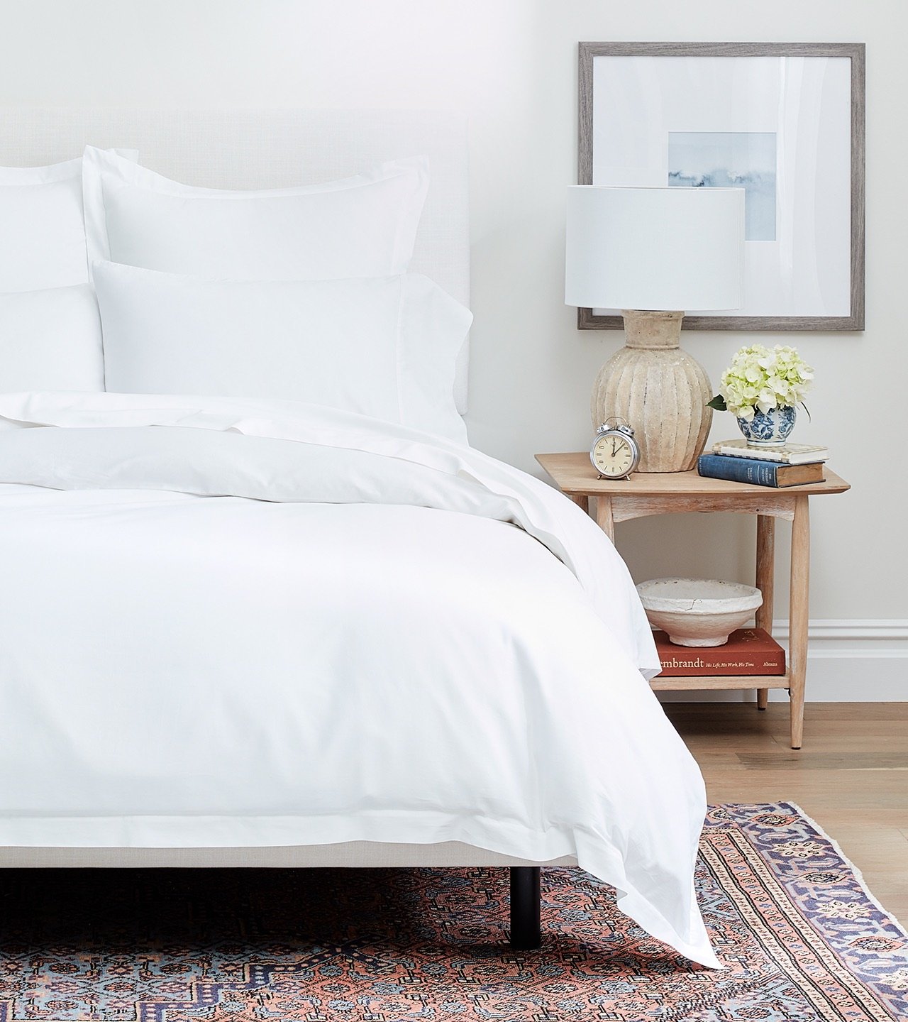 Image of a bed made with white bed sheets