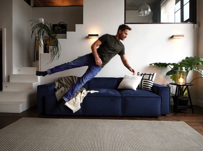 Man jumping onto Model 03 3 Seater in Teal Velvet