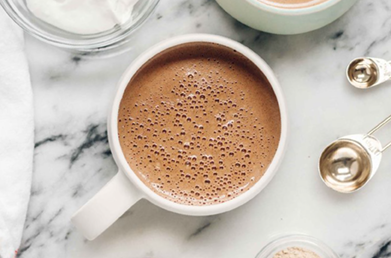 A mug of hot cocoa made with Navitas Organics Unsweetened Cacao Wafers