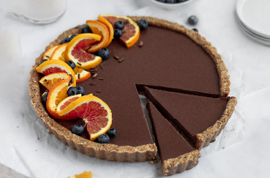 A sliced chocolate tart made with Navitas Organics Unsweetened Cacao Wafers