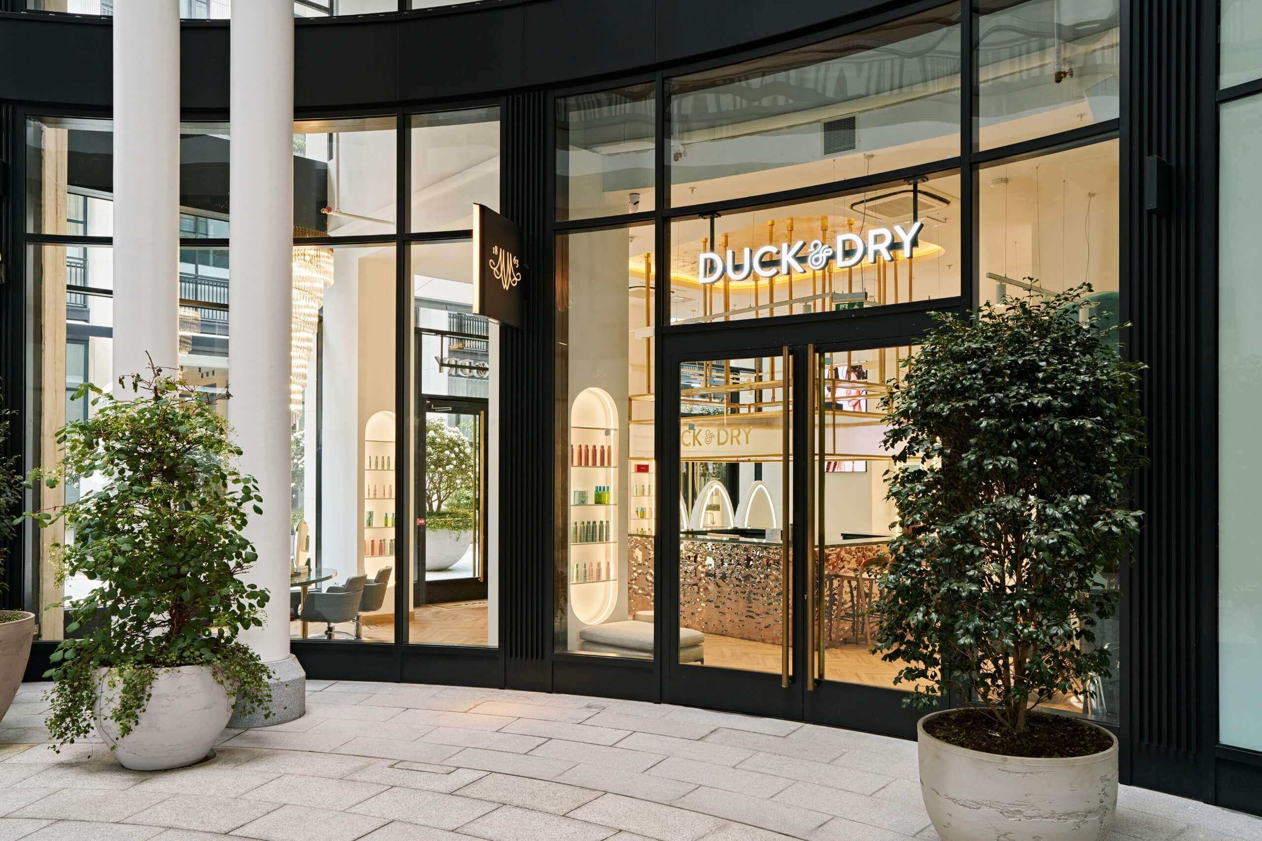 Duck & Dry salon shopfront with the glass frontage showing the reception, product shelves and styling area inside