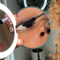 Woman using the Taylor compact with 1X and 10X magnification