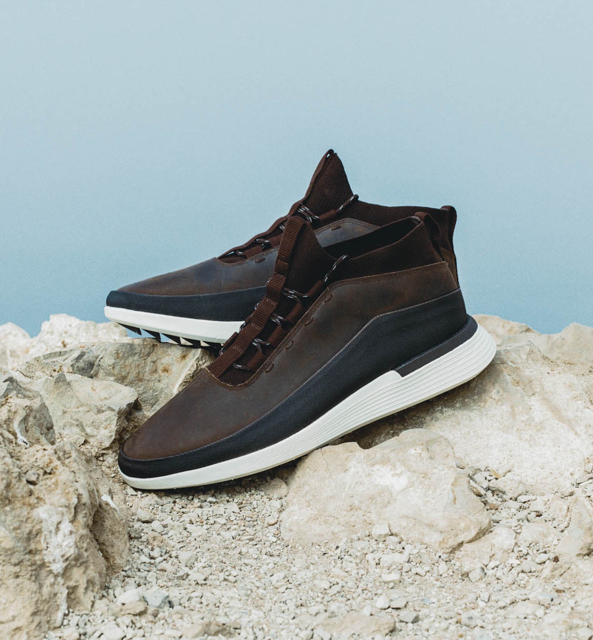 Side view of Men's Boot Crossover Mid WTZ in Brown on a rock with the ocean in the background