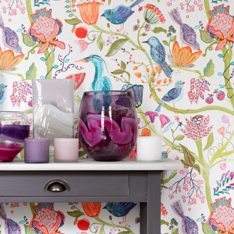 multicoloured floral wallpaper sample lindu behind table with glass vase