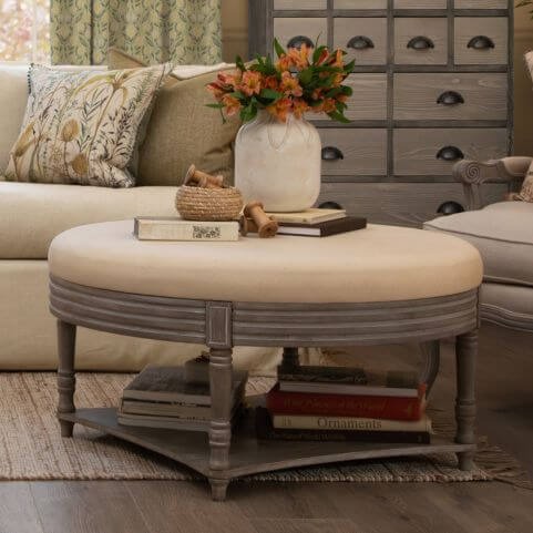 A wooden footstool holding a vase of spring flowers in a summer decor style living room.