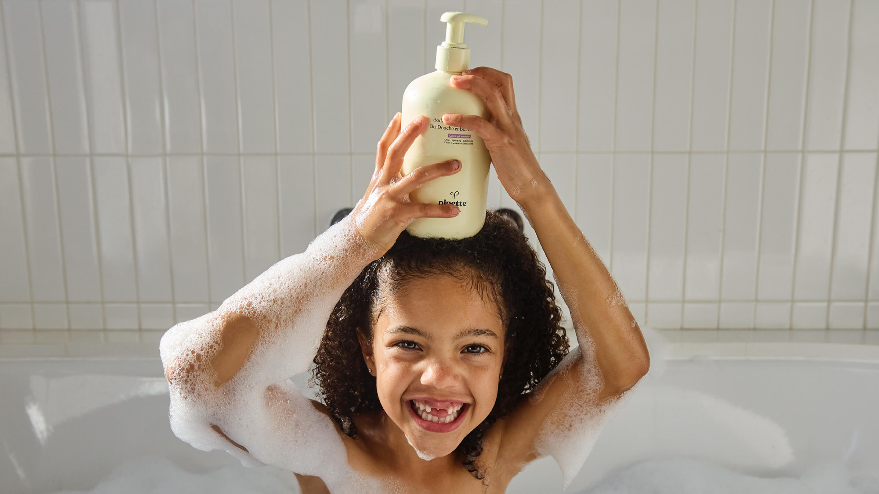 Little Girl Holding Bubble Bath in Wild Berry in Bubble Bath.