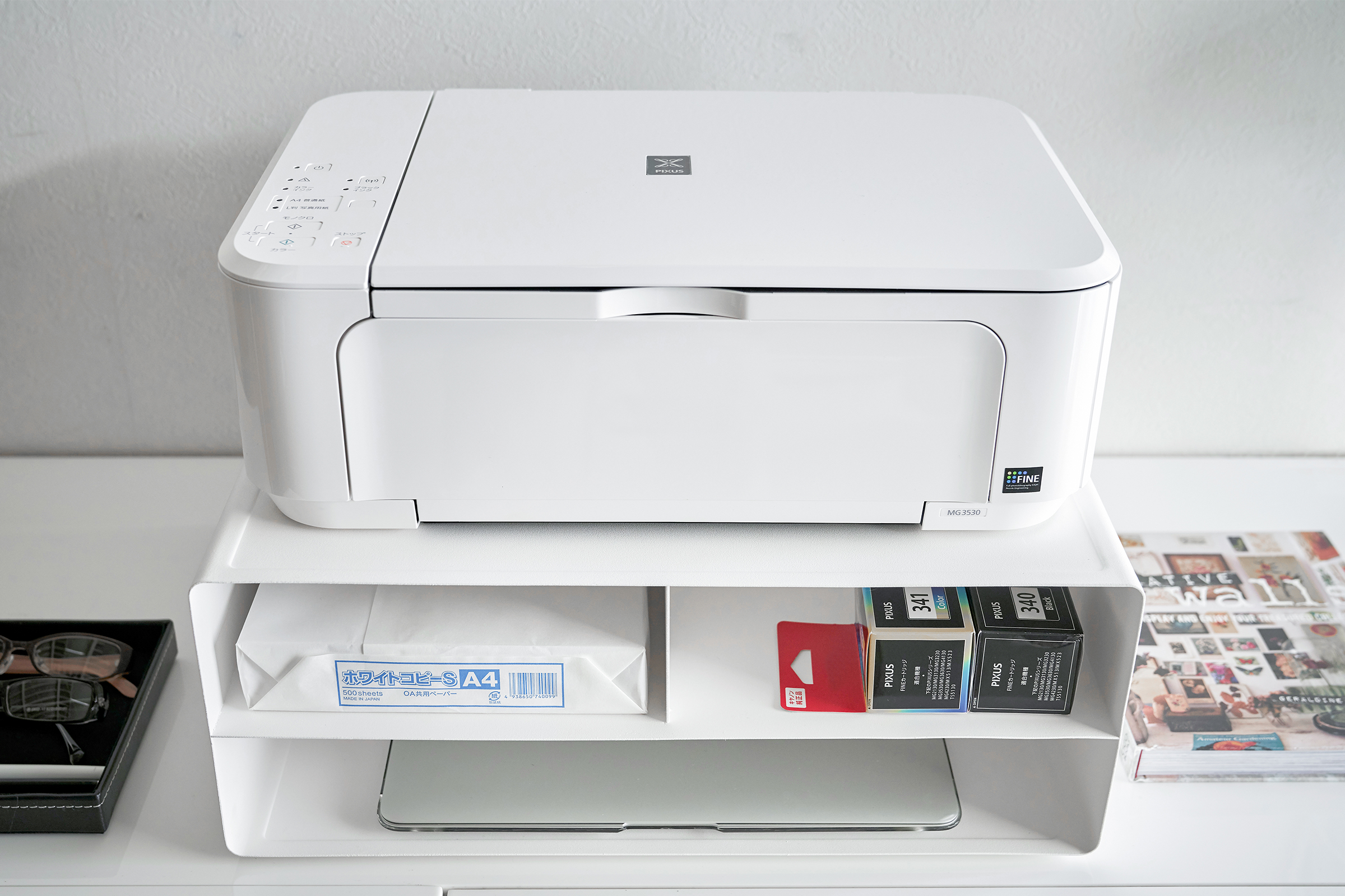 Front view of white Rolling Printer Stand under printer and holding paper, ink, and computer by Yamazaki Home.
