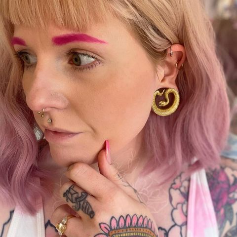 female wearing shiny  Gold Snake Saddle Metal Ear Gauge / Plug
