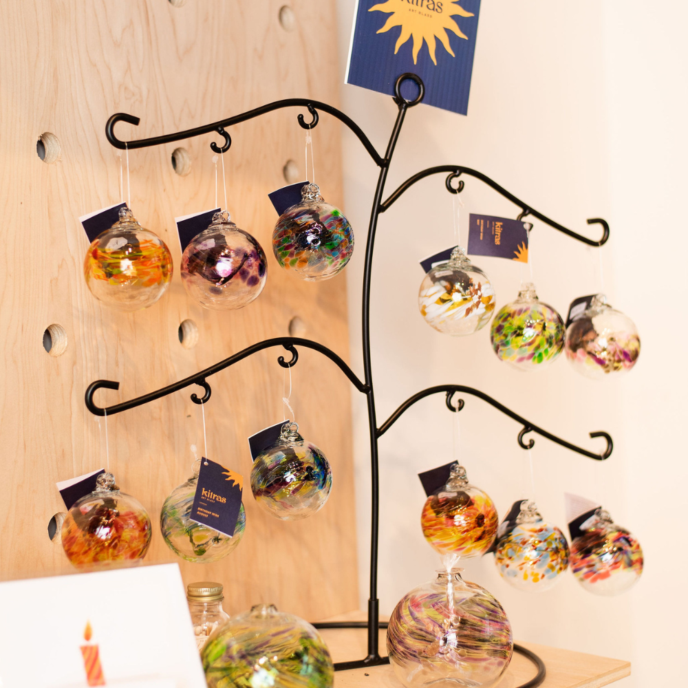 All Birthday Wish ornaments on a Birthday Ball stand. Displayed on a wood shelf.