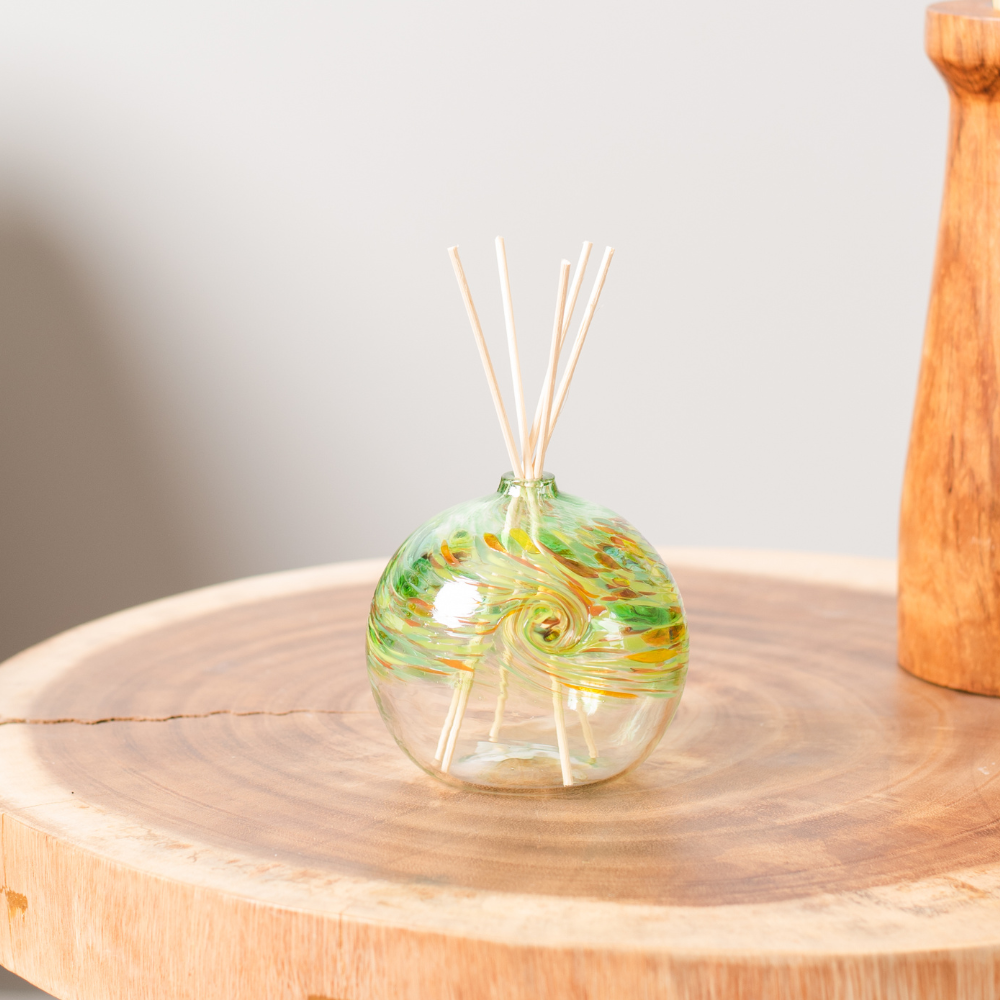 Green Earth Diffuser on a wood table with reeds