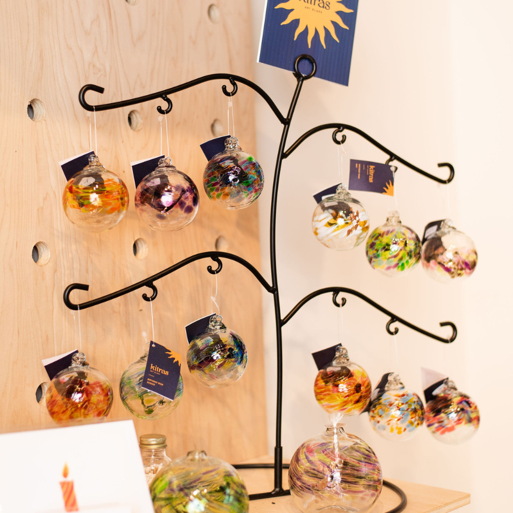 All Birthday Wish ornaments on a Birthday Ball stand. Displayed on a wood shelf. 