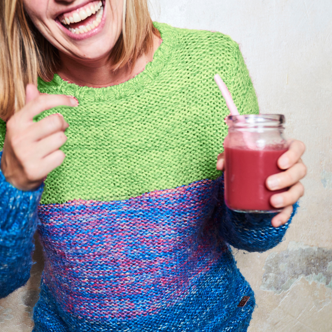 girl smiling with wildberry smoothie