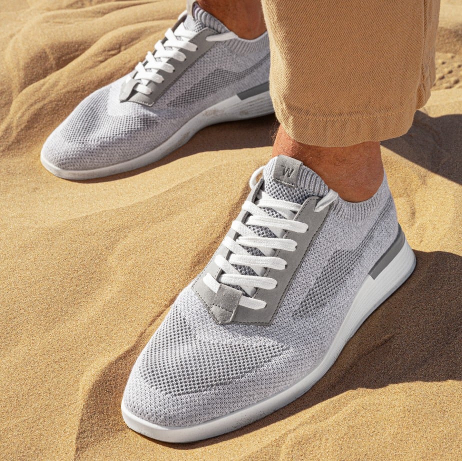 Ankle down view of supremeknit trainer gray with a sand background