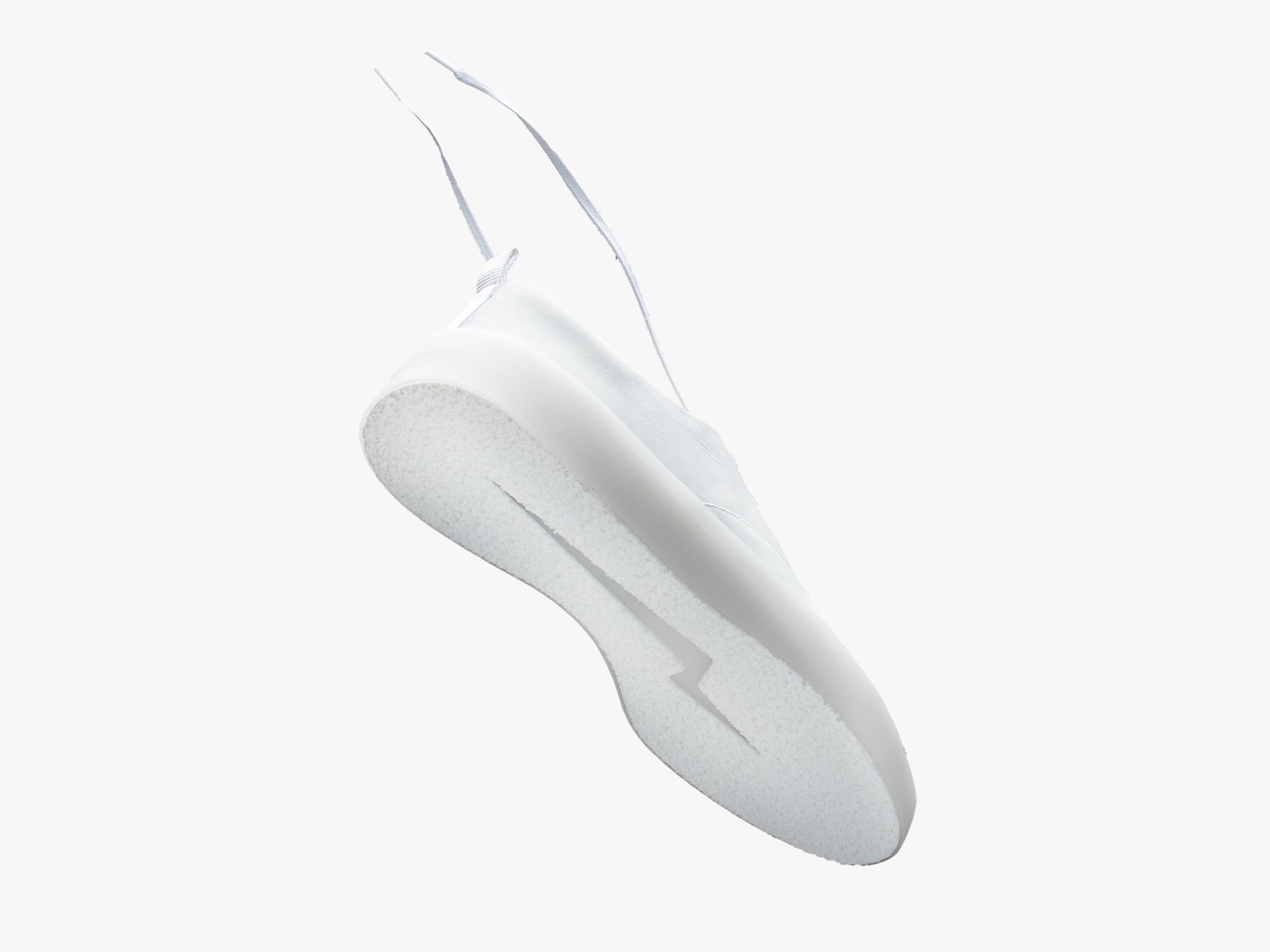 Cruise Lace up shoe in white on a white background, floating mid air, exposing the sole of the shoe