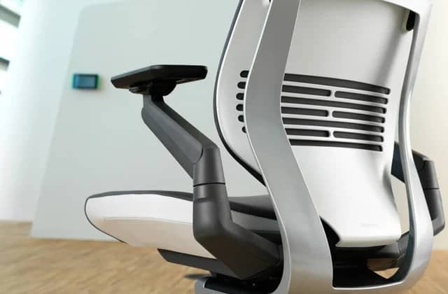 Silla de oficina Steelcase Gesture en negro, mirando hacia atrás a la izquierda, mostrando el mecanismo de tensión del respaldo, en una habitación vacía.