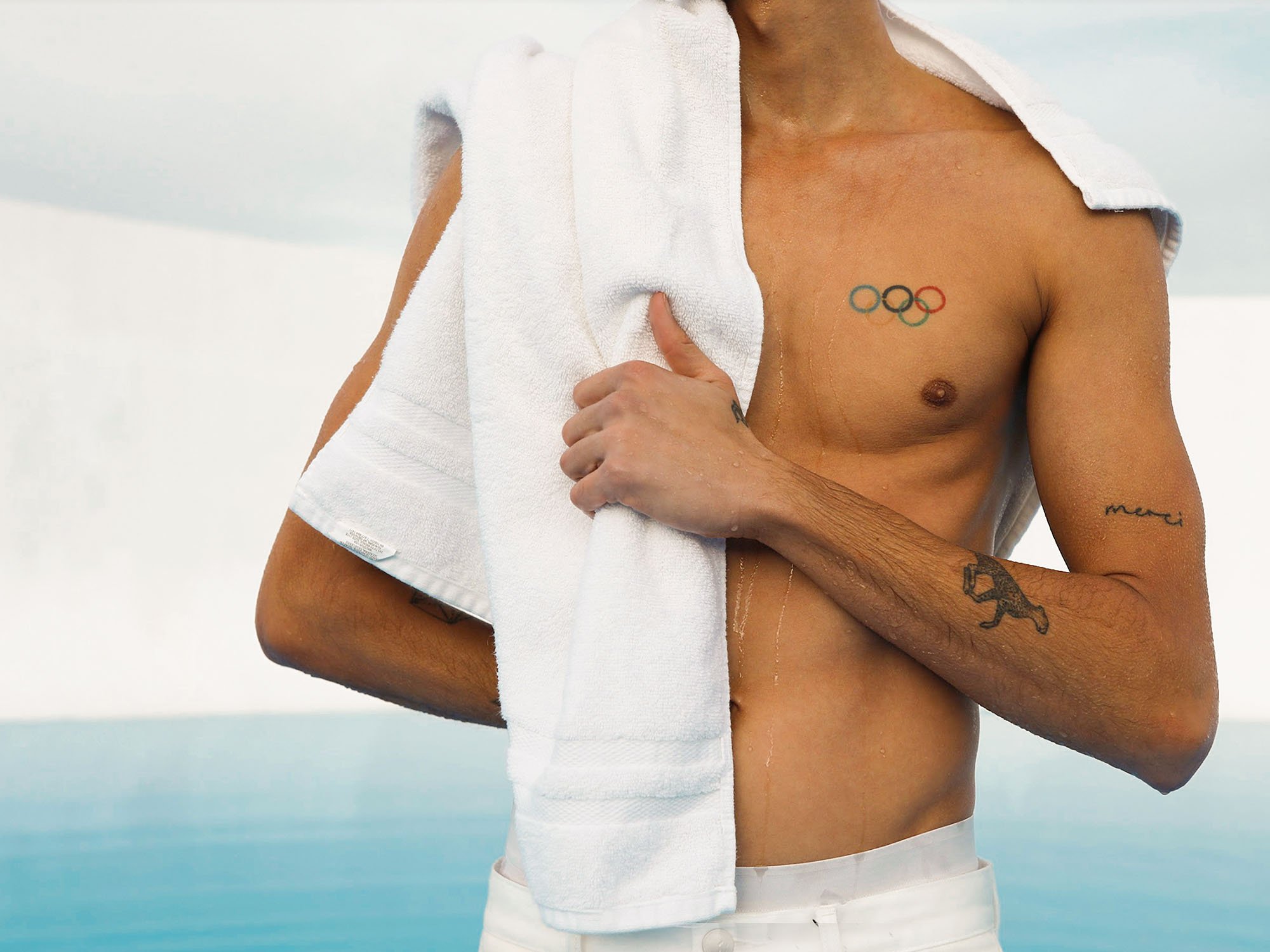 Shirtless man holding towel over his shoulder