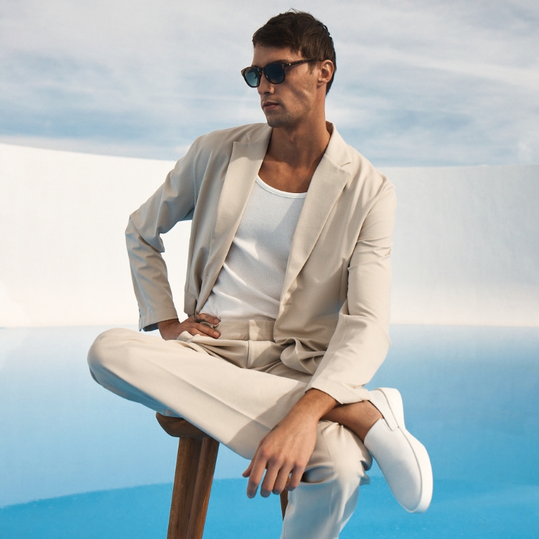 Man sitting wearing Men's Shoe Cruise Slip on in White , white background and blue floor