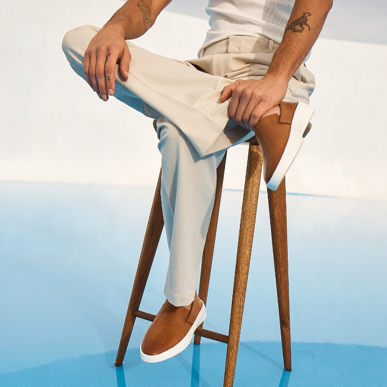 Shoulder down view of Man sitting wearing Men's shoes Cruise Slip on in Honey