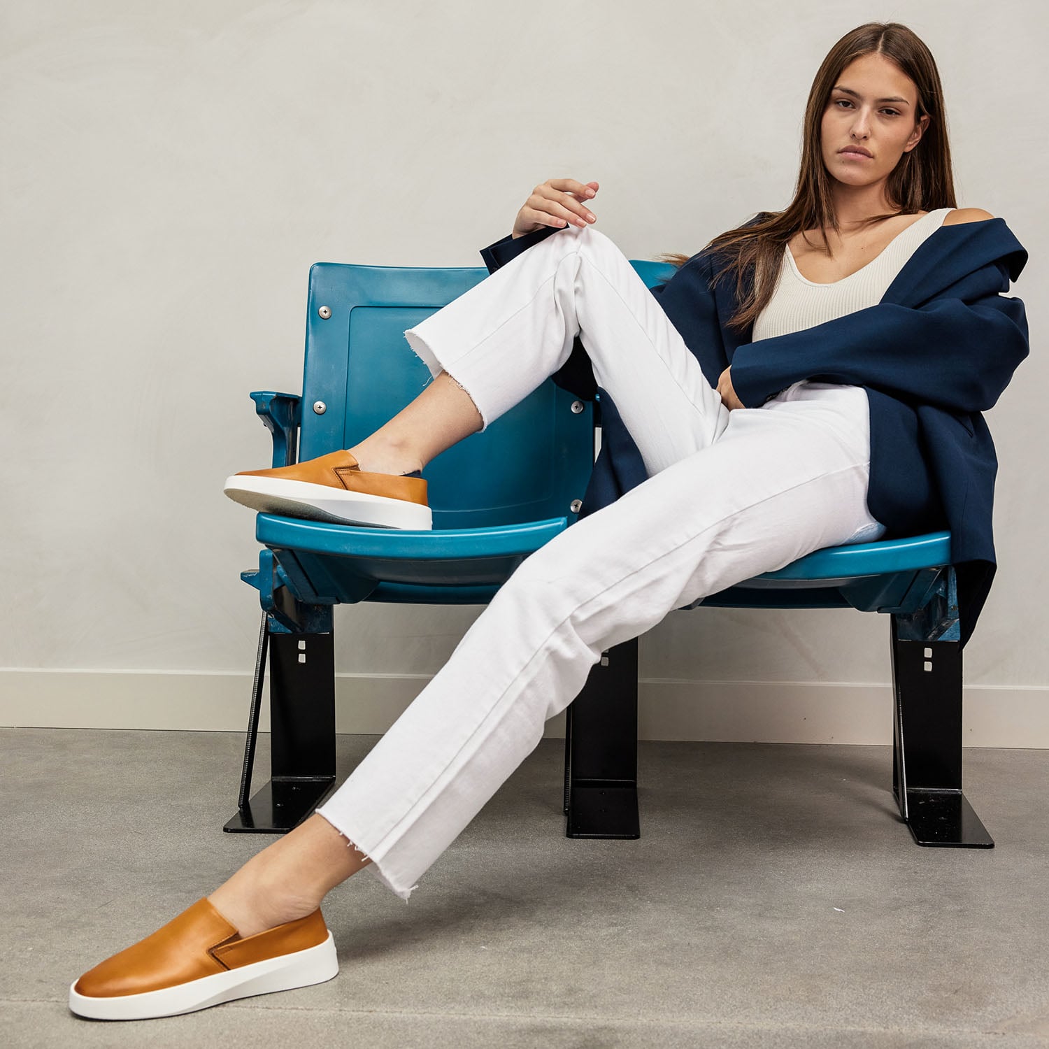 Full body view of Woman sitting on bench wearing Women's Shoe Cruise Slip On in Honey