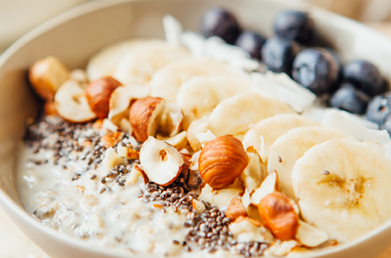 An oatmeal bowl topped with fruit, nuts and chia seeds