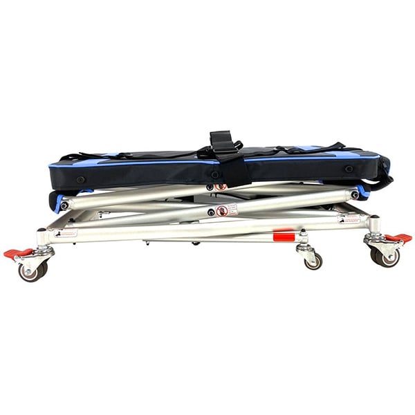 The So Lite Portable Lift by Journey Health & Life Style is a compact medical stretcher designed for easy transportation and storage. It features a sturdy metal frame with blue padding, locking caster wheels, and adjustable straps. The addition of red and silver elements enhances its functionality and safety, ensuring reliable mobility in any situation.