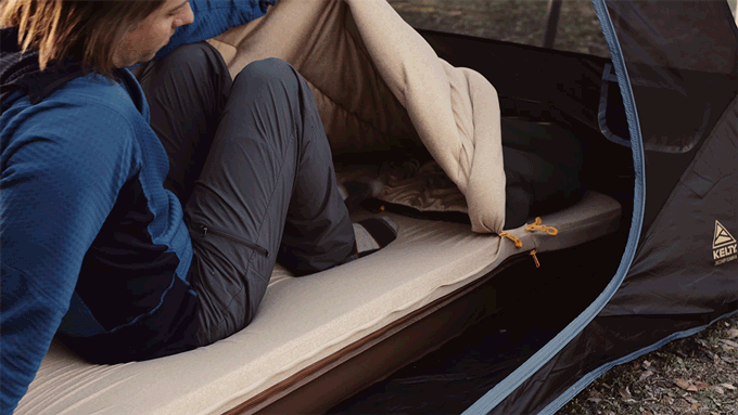 Man putting his feet inside of the footbox of the Kammok Ursa Sleep System camp comforter.