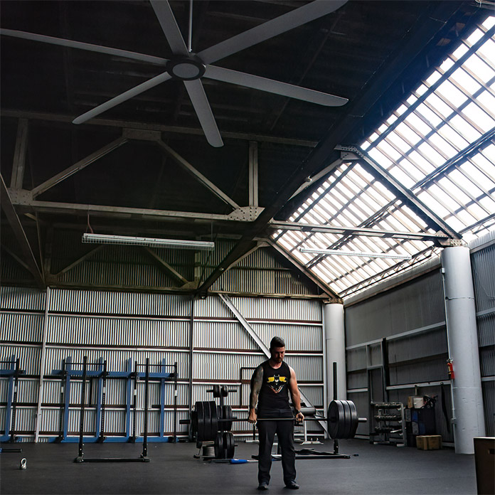 An HVLS fan works in a large open gym to cool athletes. 