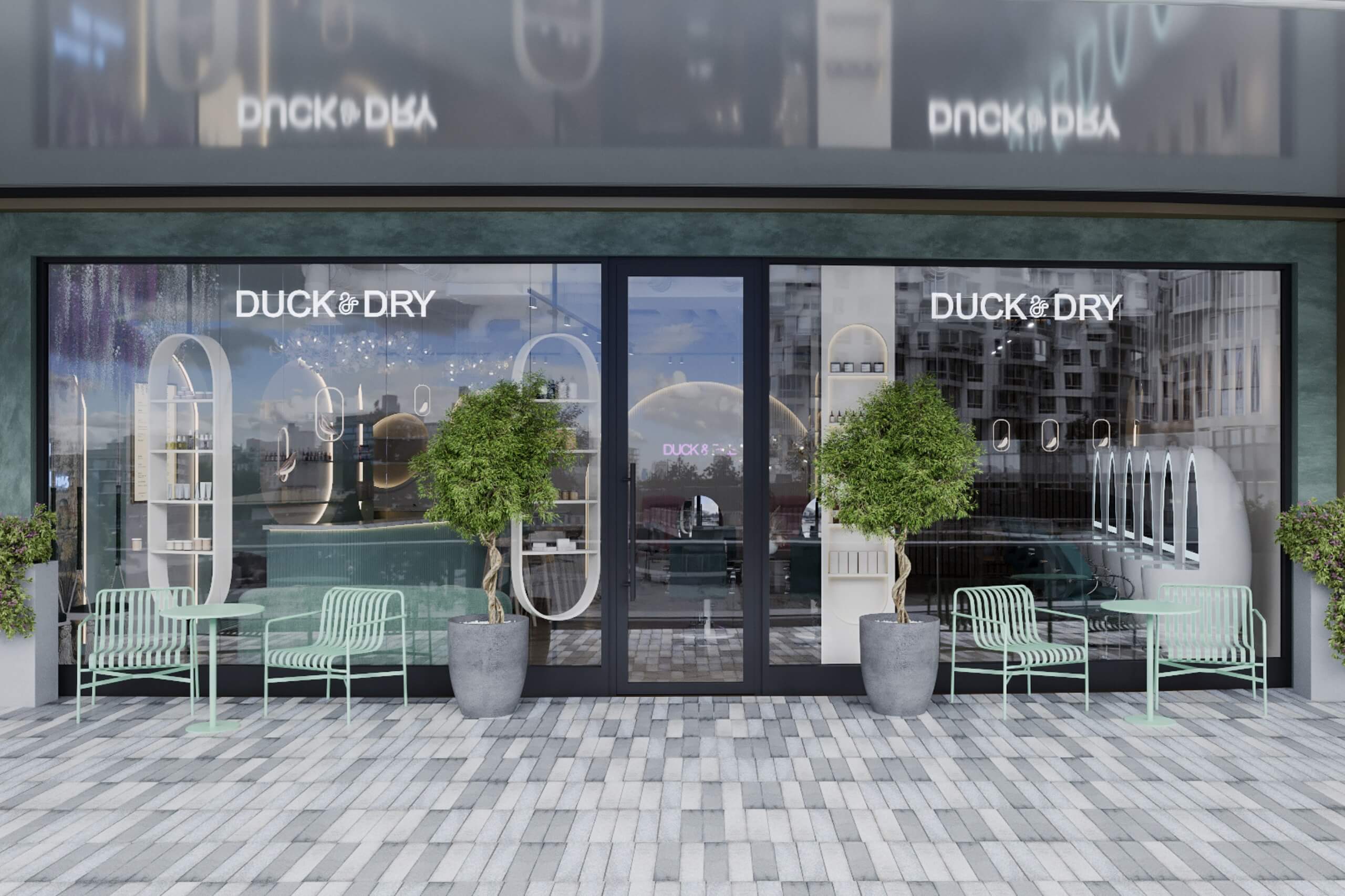 Exterior storefront of Duck & Dry Battersea hair salon, featuring large glass windows, outdoor seating with green chairs, and a view into the styling area.
