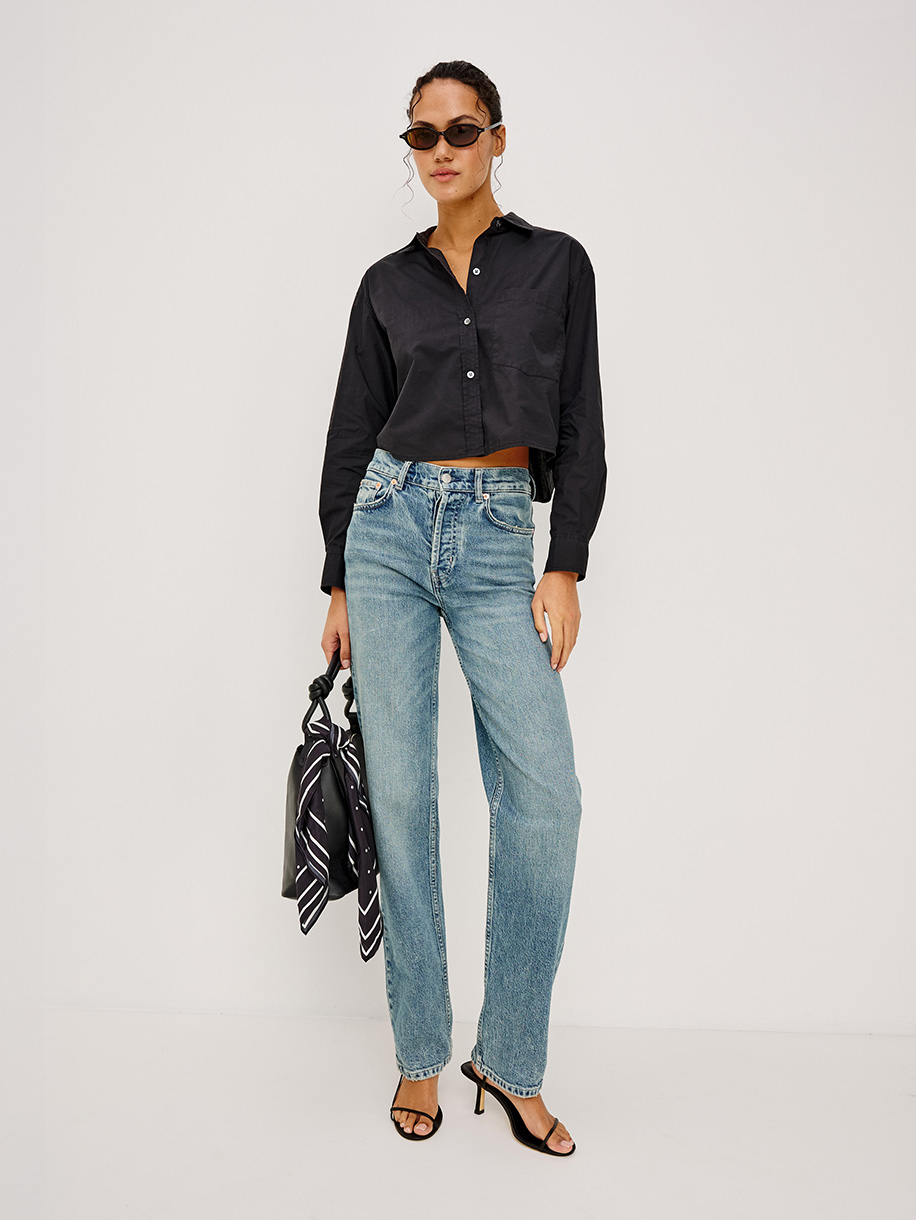 Woman in straight fit jeans on white background. Click here to shop Straight Fit Jeans
