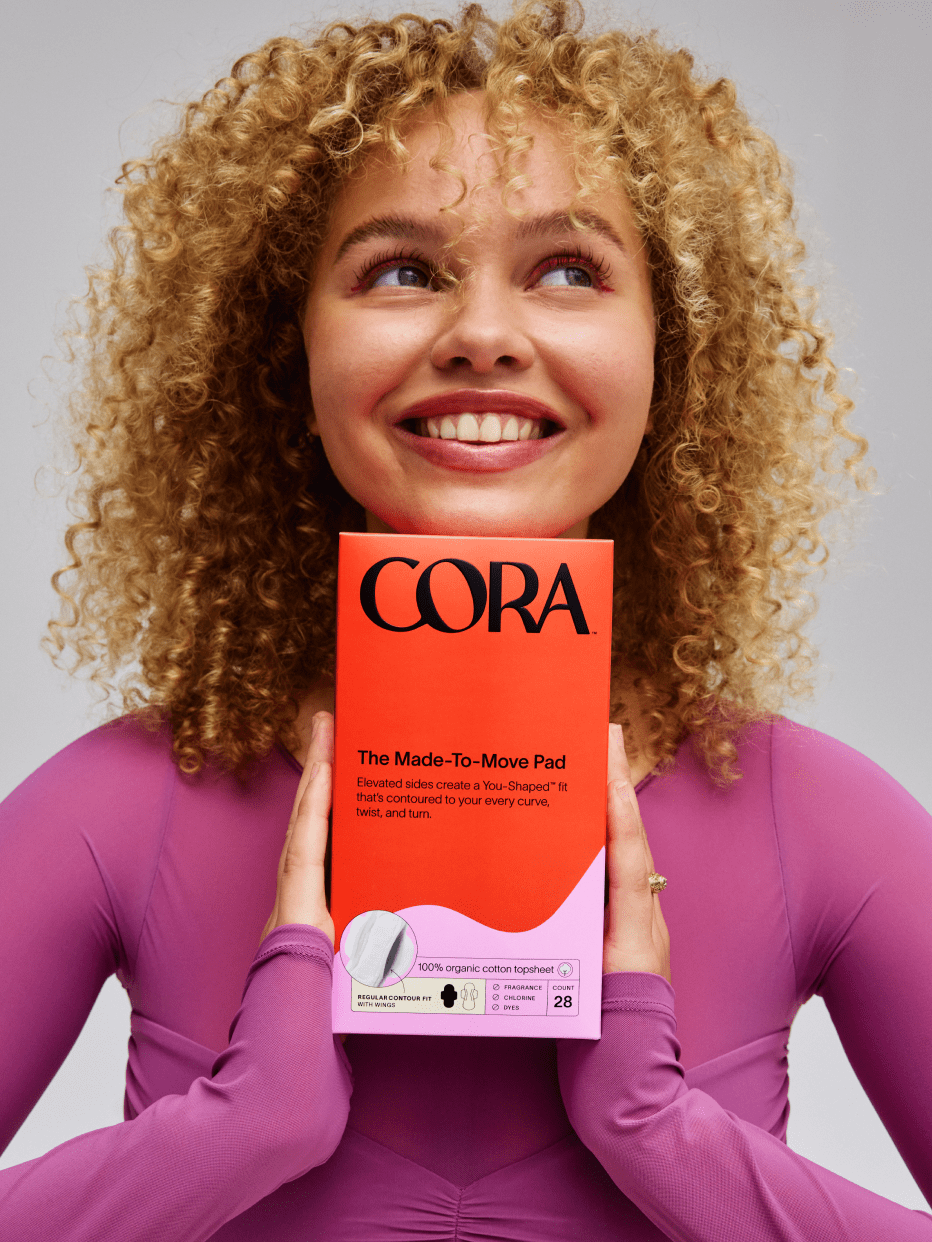 A person smiling holding a box of pads