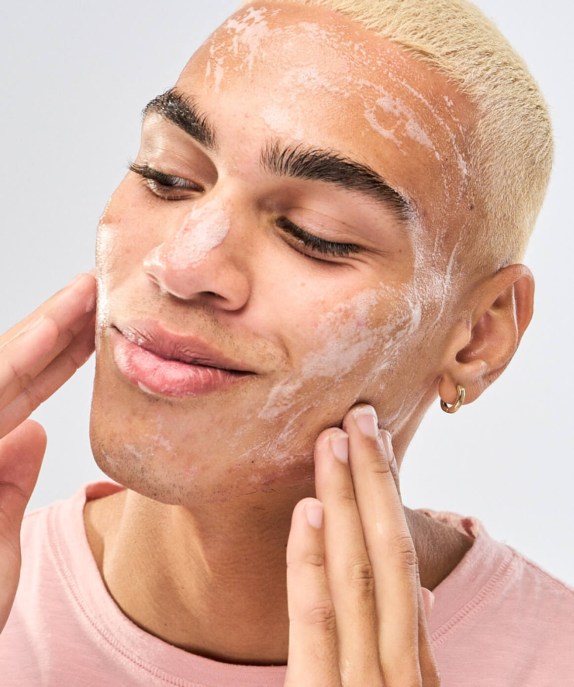 Young male applying skincare product. Gel cleanser for all skin types. 