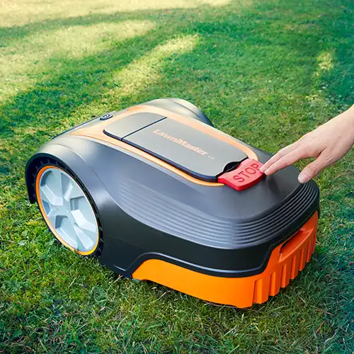 Stop button on LawnMaster L12 robot mower being pressed