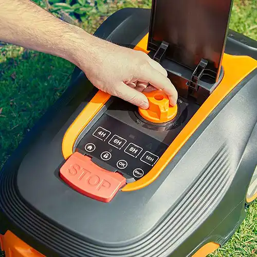Person adjusting cutting height of LawnMaster L12 robot mower