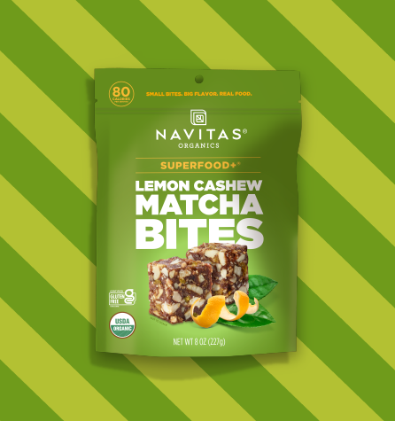 A package of Navitas Organics Superfood+ Lemon Cashew Matcha BITES against a two-toned striped green background.