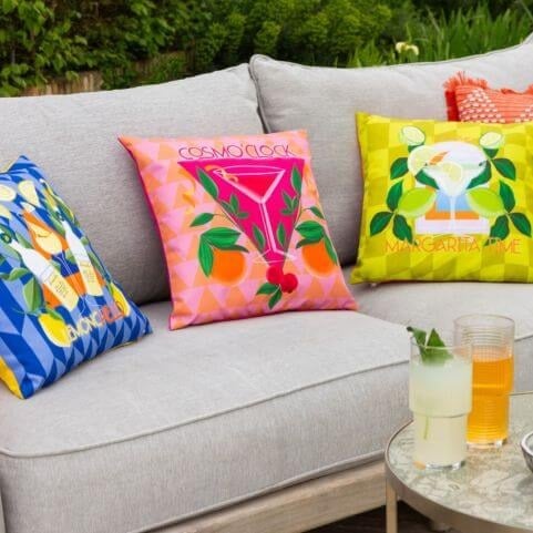 An outdoor entertaining area in a living room style, featuring a garden sofa decorated with cocktail outdoor cushions.