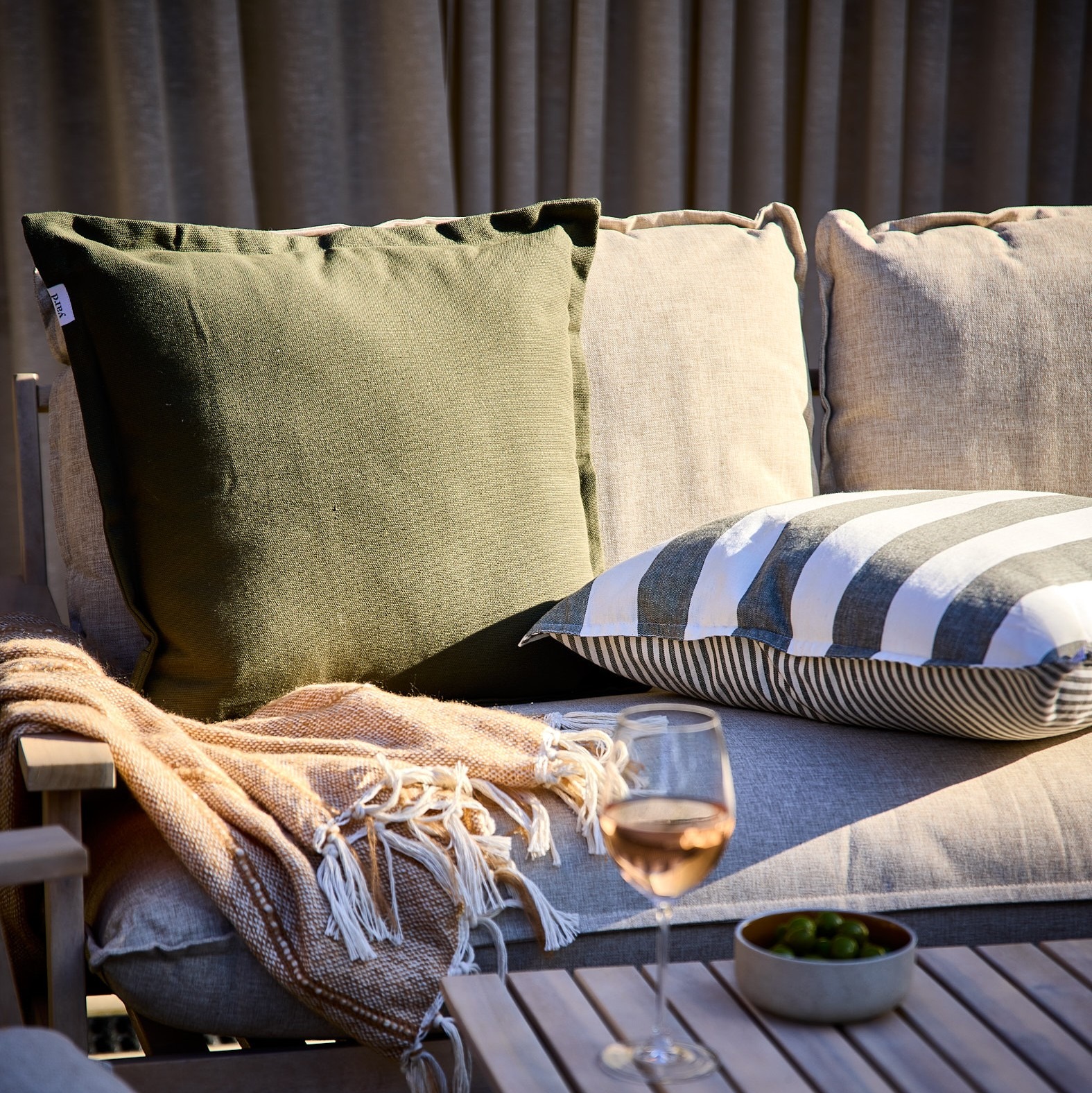Green outdoor cushion and a striped on next to it