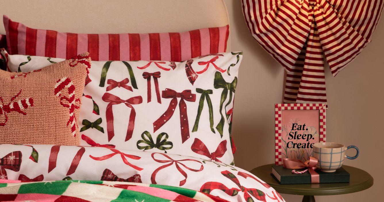 A festive duvet cover set featuring red and green bows and Christmas cushions