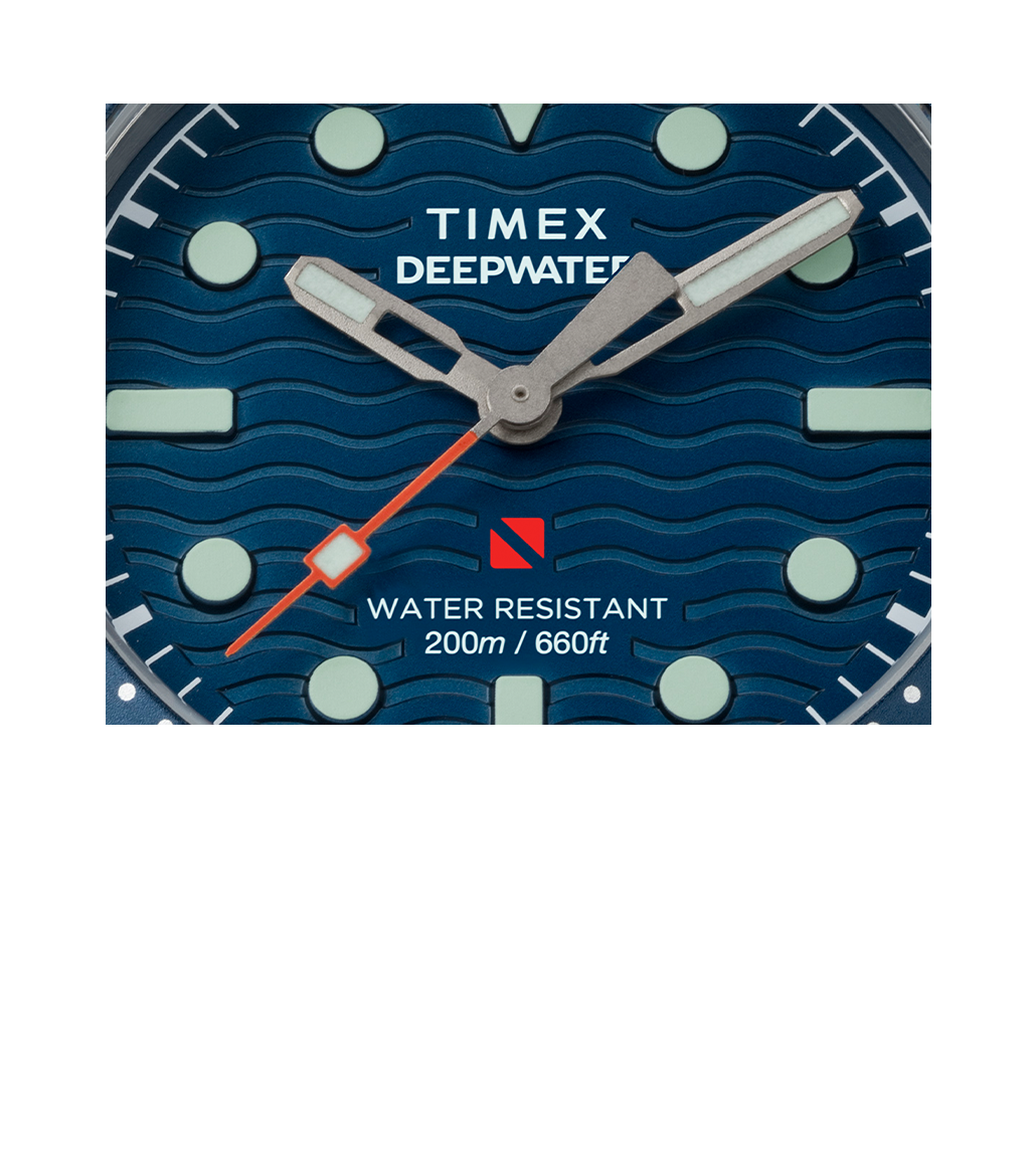 Extreme close-up of the Timex Deepwater Reef 200 dial. Showcases the wave-pattern texture, red square-tipped seconds hand, bold luminescent indices, and printed text reading “WATER RESISTANT 200m / 660ft” with the diver-down red flag icon.