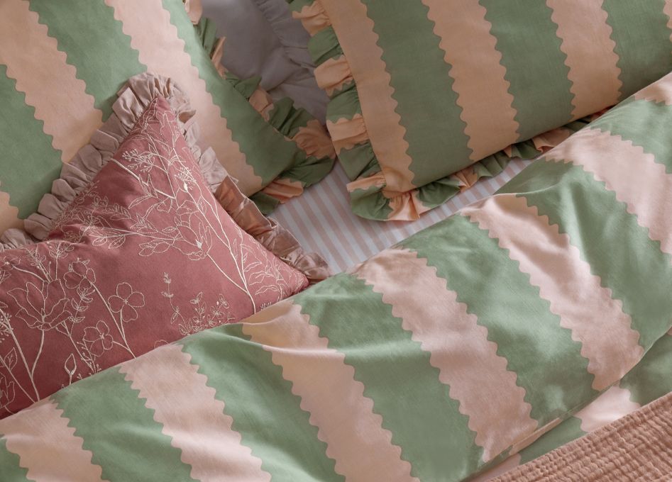 A pretty, frilly bed in green and pink.