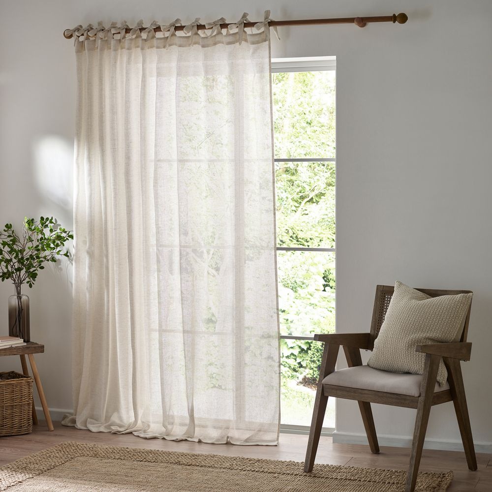 Sheer cream curtains with a tie top header in a living room