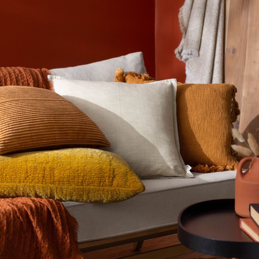 Orange colour drenched sofa featuring orange cushions on a cream sofa with orange walls