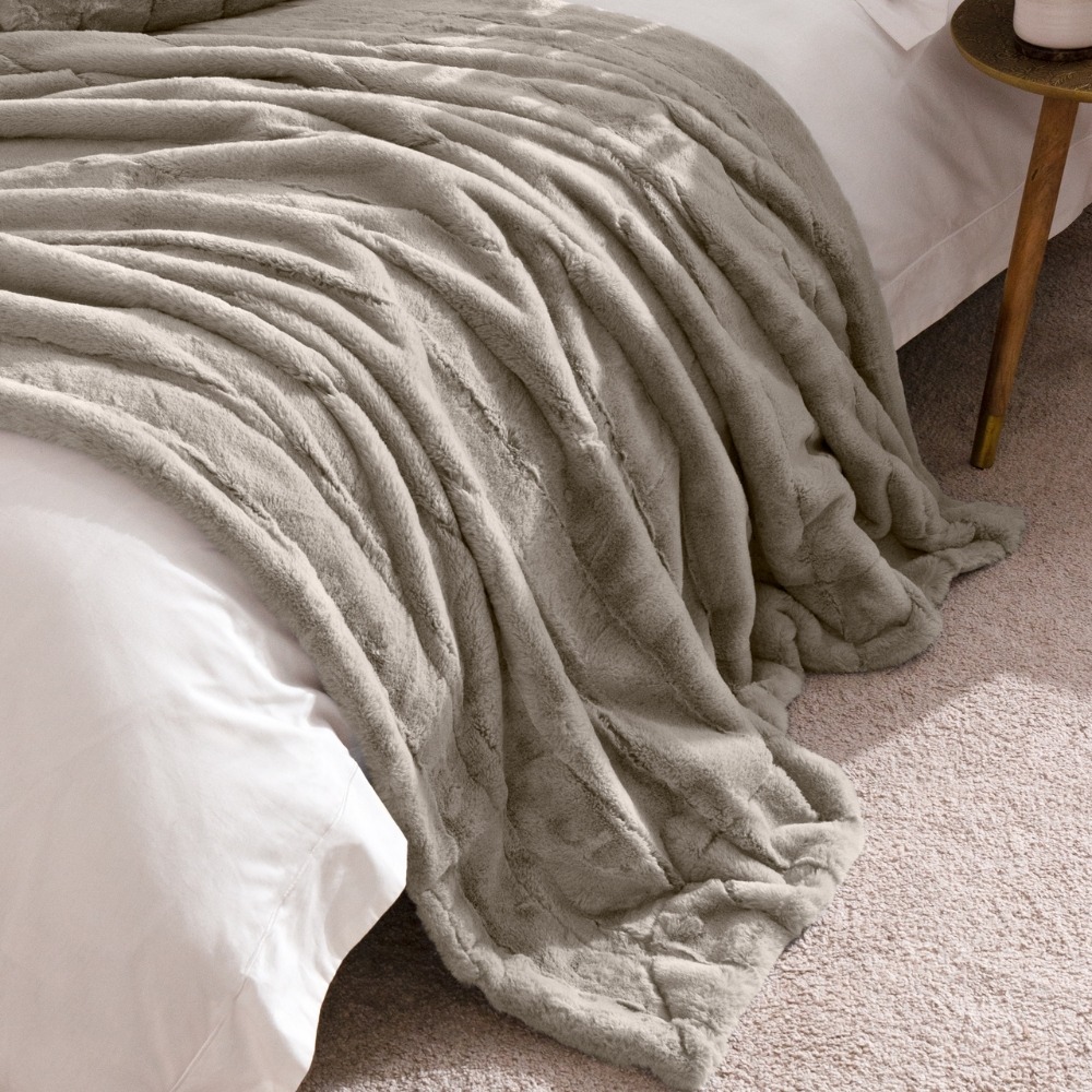 plain white bedding with a faux fur grey throw.