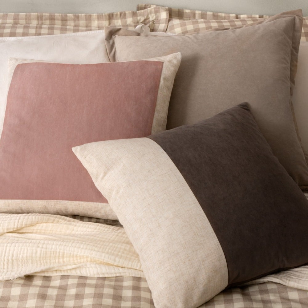 natural coloured check bedding with grey cushions and a light pink velvet cushion.