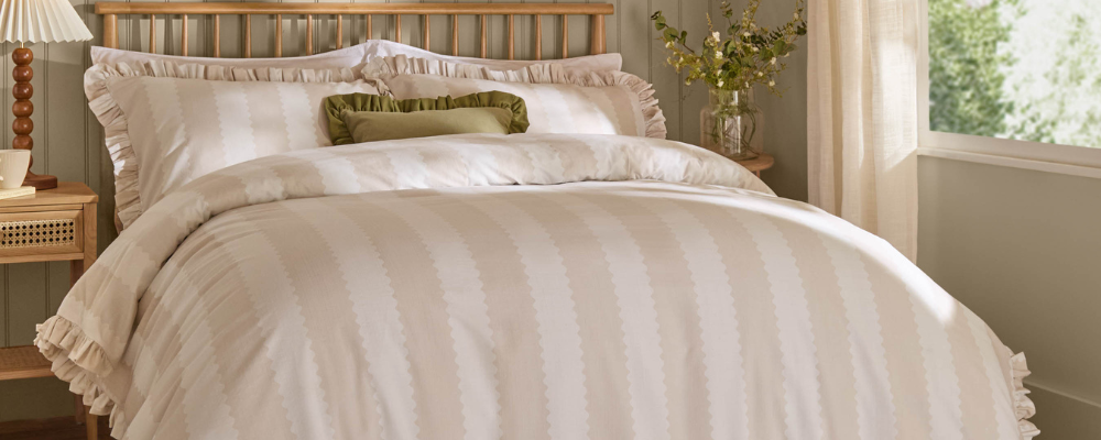 A double-sided stripe design in beige is framed with delicate ruffle trim, adding a whimsical hint of cottage core charm, with an olive green ruffle cushion in the centre