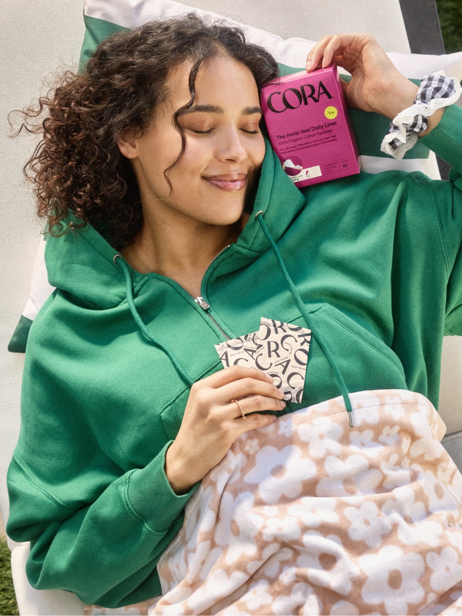 A woman laying down holding a box of micro liners