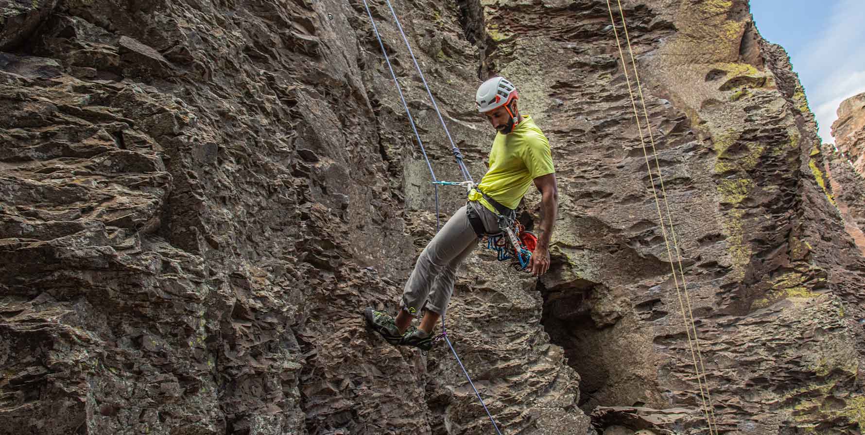 Rock climber descending down the side of the Feathers at the Frenchman Coulee park while wearing the SolarSwift Short Sleeve Shirt and Tarngood pants by Beyond Clothing. 