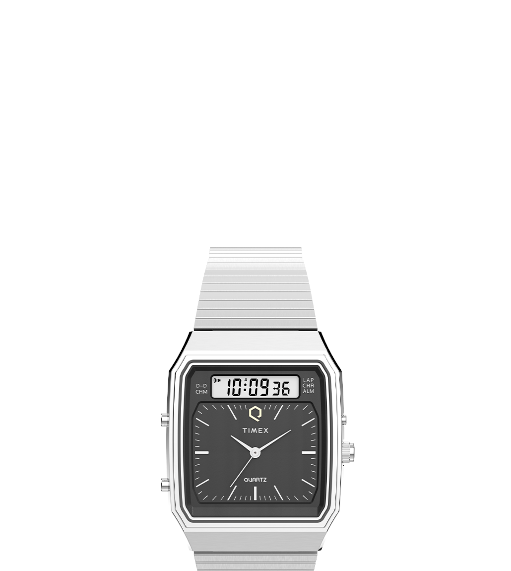 A Q Timex® 1982 Ana-Digi Reissue watch in a silver-tone finish with a black dial, showcasing its hybrid analog and digital display. The rectangular case design and sleek stainless steel bracelet highlight the vintage-inspired aesthetic.