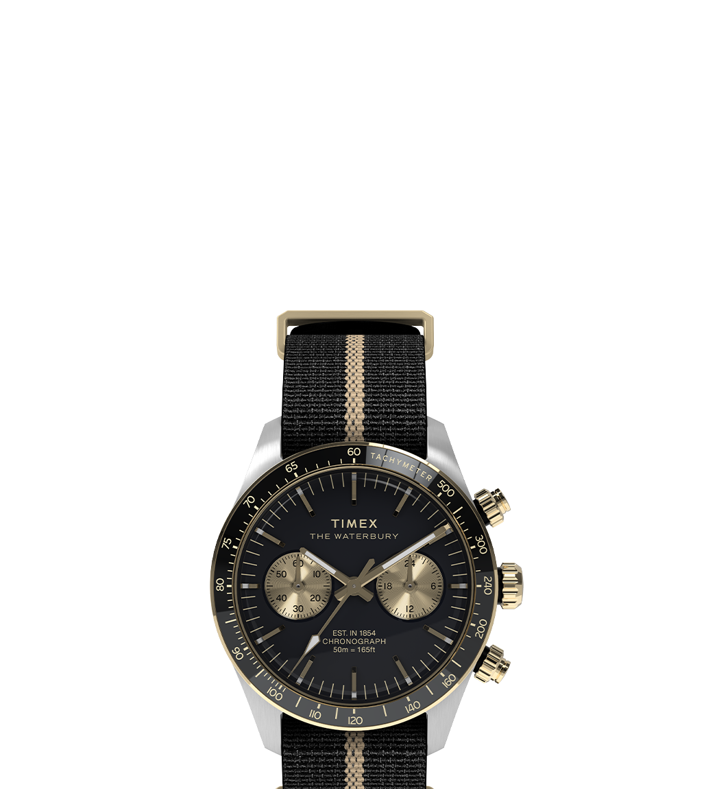 Front-facing product image of the Timex Waterbury Heritage Chronograph, showcasing a black dial with gold-tone markers, two champagne-colored sub-dials, and a black-and-tan nylon strap with matching gold-tone buckle and crown.