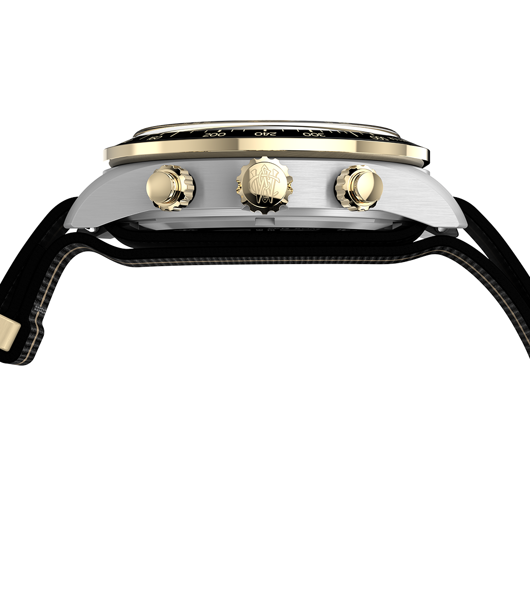 Side view of the Timex Waterbury Heritage Chronograph watch, displaying its brushed stainless steel case, gold-tone crown and pushers, and a slightly domed crystal above the tachymeter bezel.